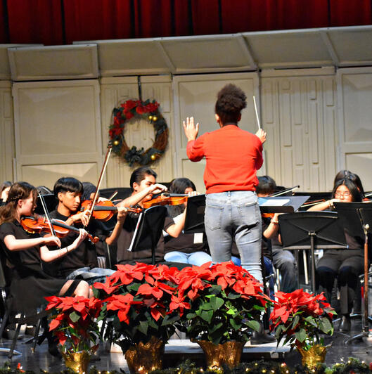 The director from Leman Middle School leads the performers in a song. (Photo by Karidja Monjolo)